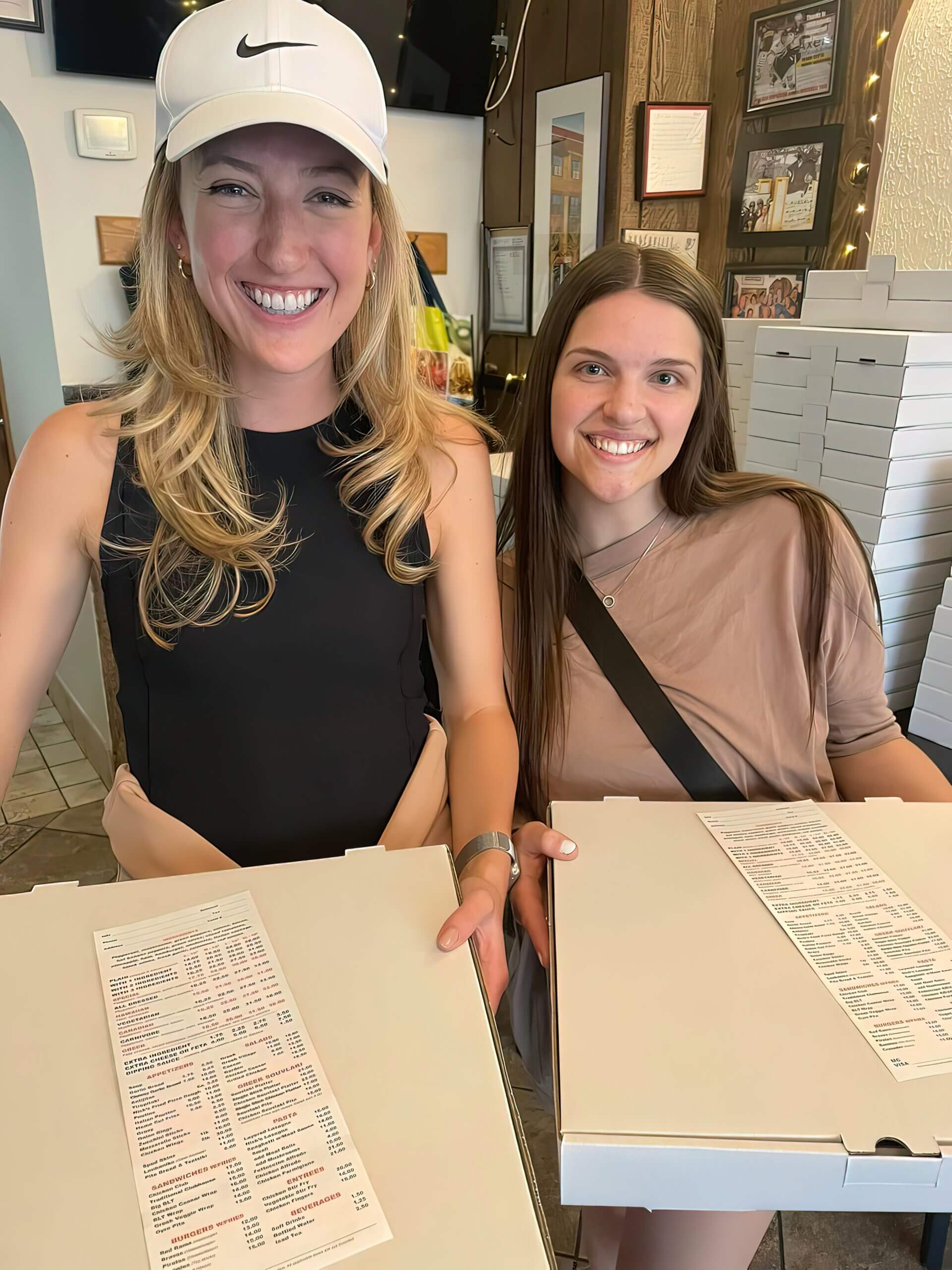 two girls holding pizza box